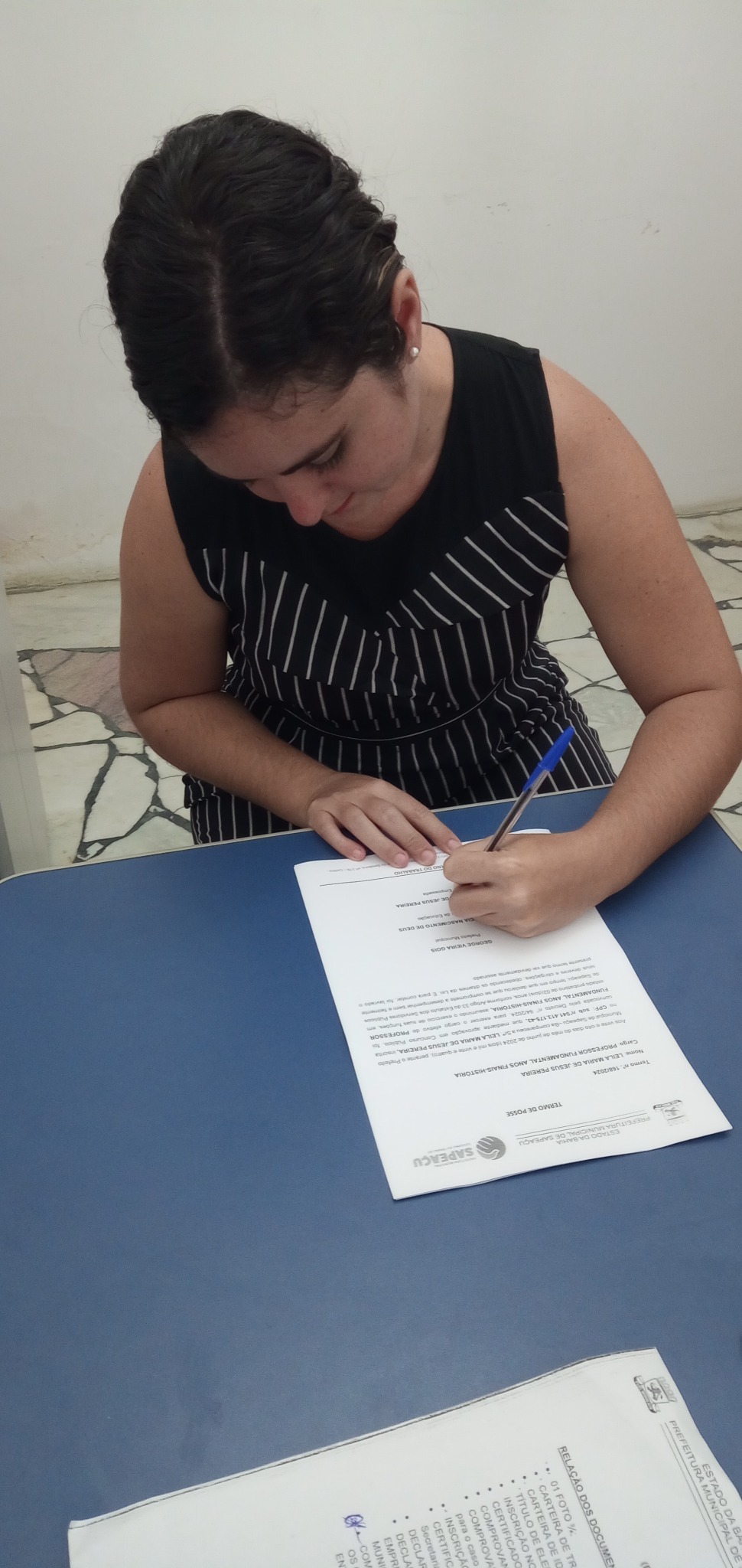Leila assinando documento de posse